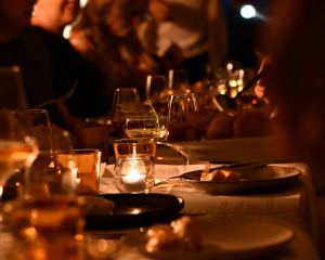 We create and curate beautiful clients for their PR and marketing needs. A candlelit dinner with happy people sharing food and wine.